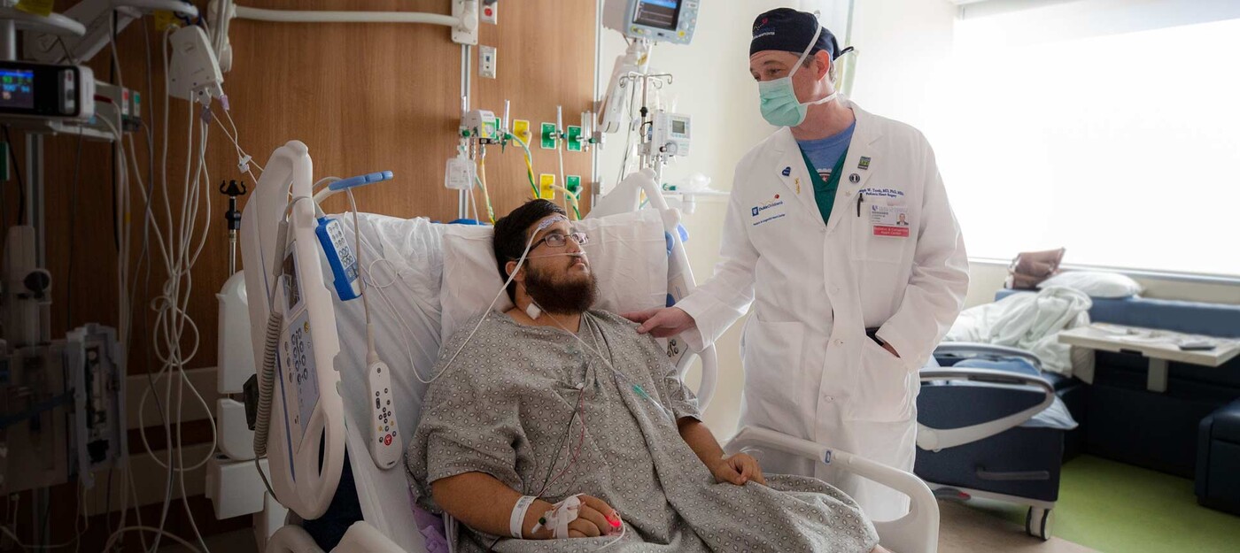 A provider speaks with a patient after surgery