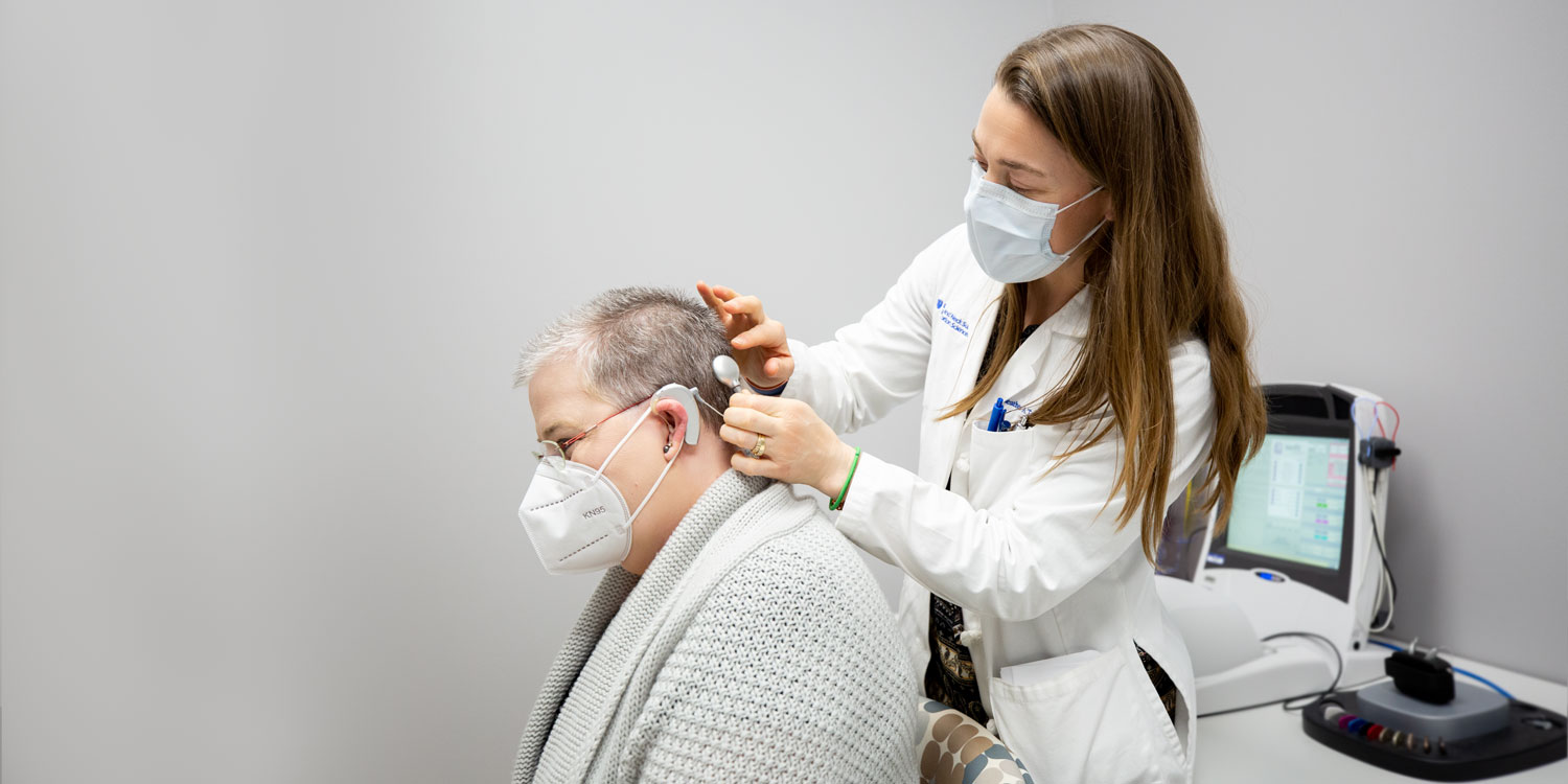 Duke audiologist Heather Toth adjusts Williamson’s cochlear implant.