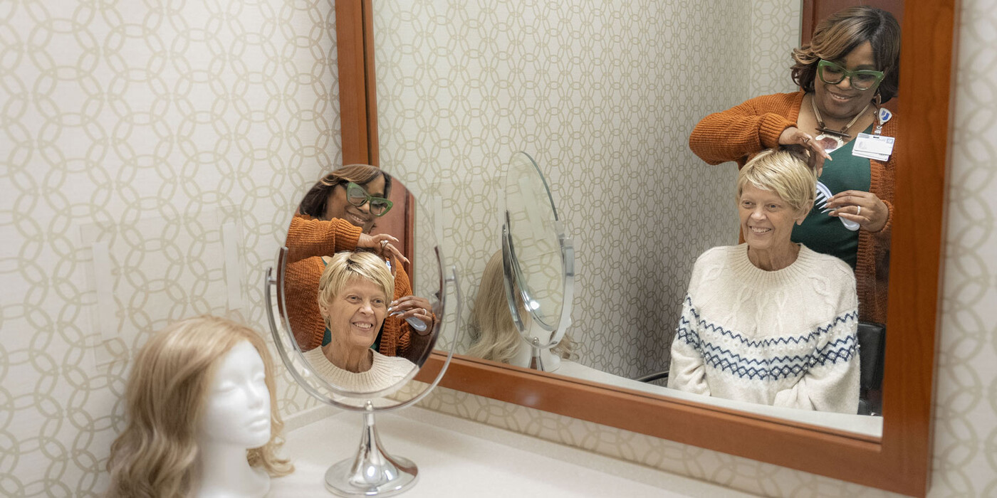 Shelby Meadows helps style a wig for Debra Calhoun at the Duke Cancer Center Raleigh Boutique