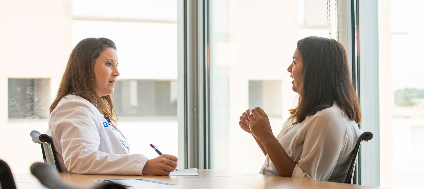 A provider takes notes as she listens to a female patient