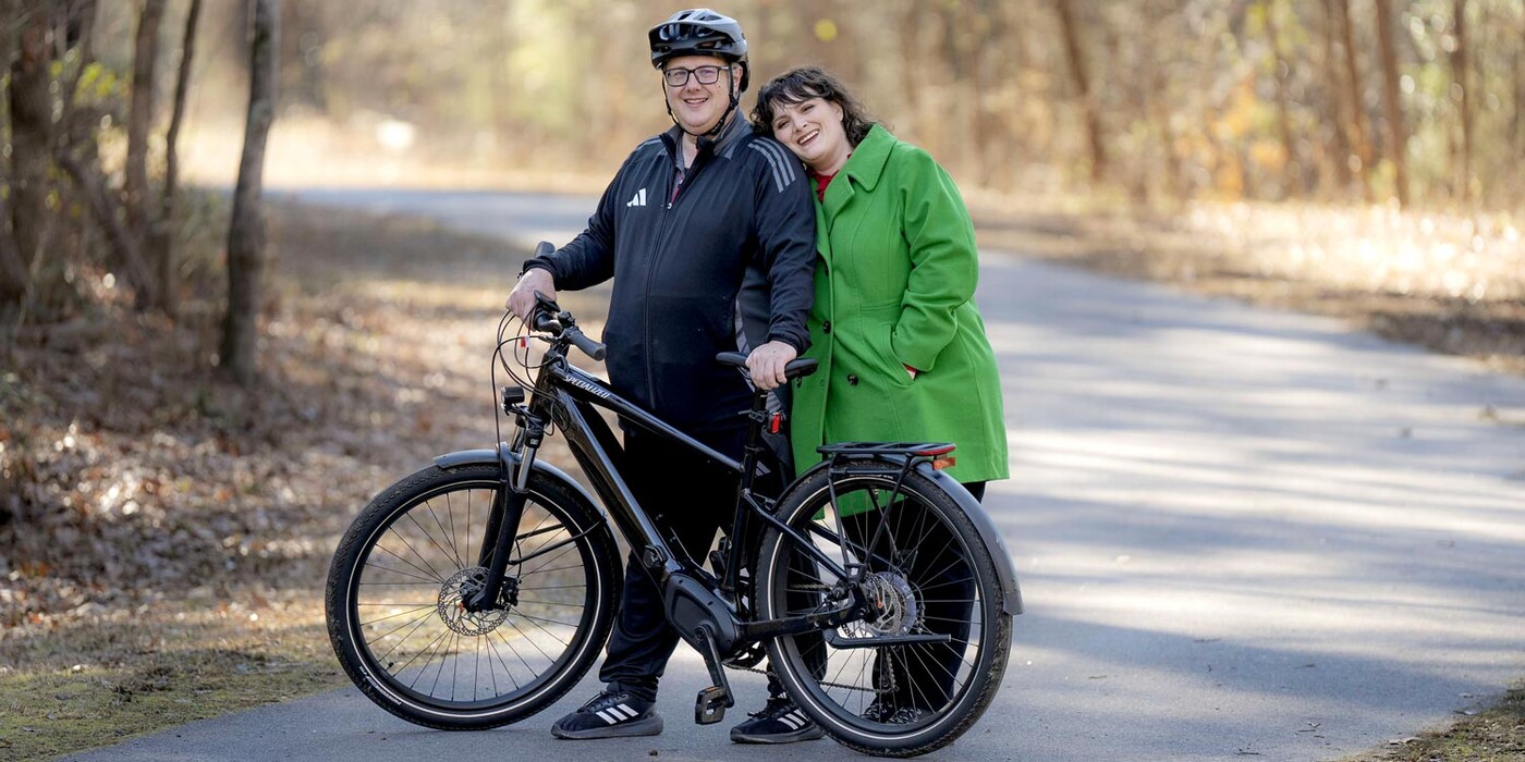 Mark Schreiner and his wife Jennifer Gaspar Schreiner pose on the Neuse River Greenway Trail with Mark's bike.