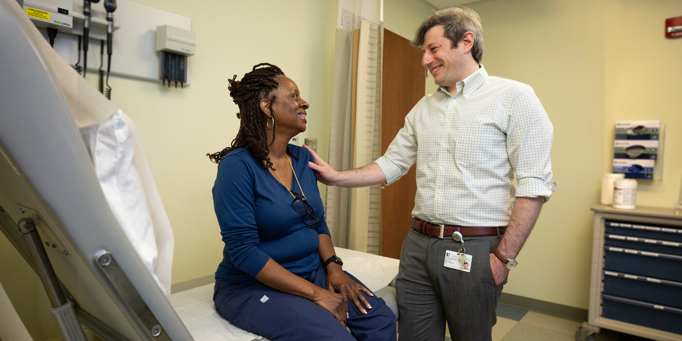 A provider speaks with a patient in an exam room