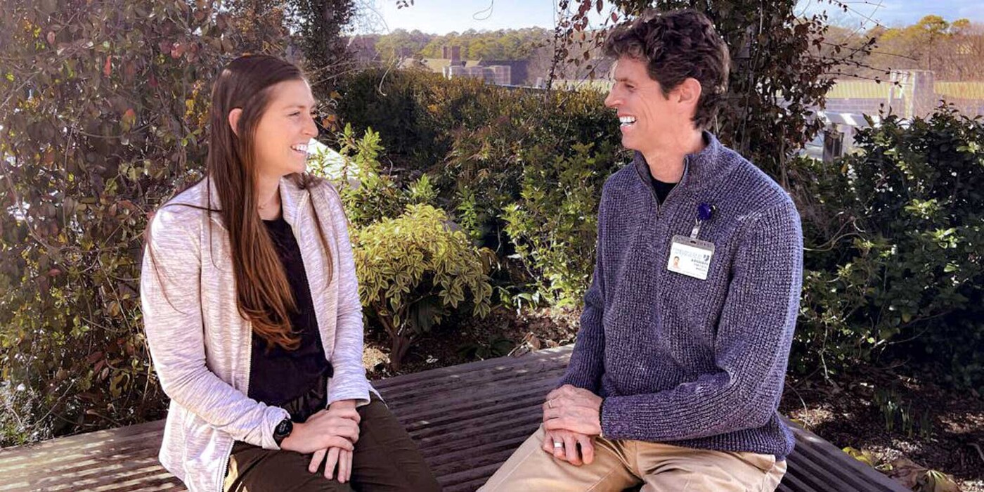Two people sit outside and talk