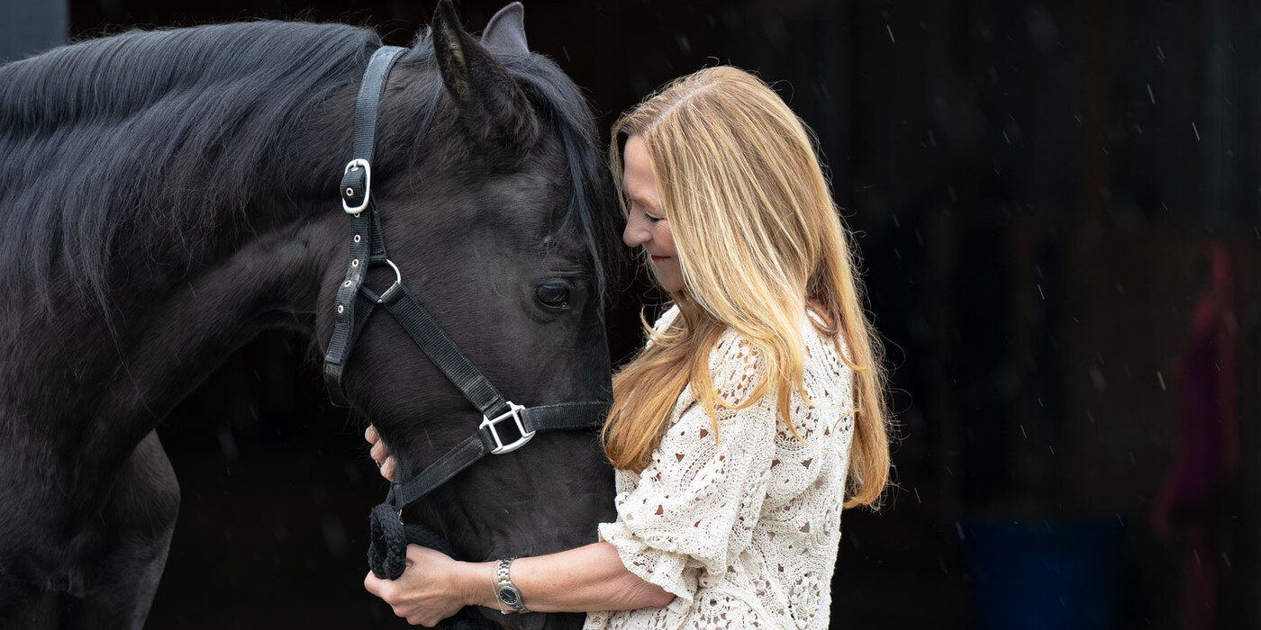 Kim faces and holds her horse's face