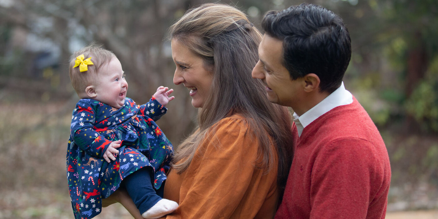 Izabel smiles outside at her mom and dad 