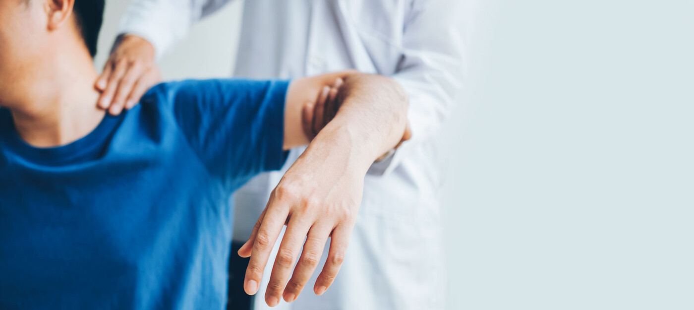 A doctor examines a patient's shoulder