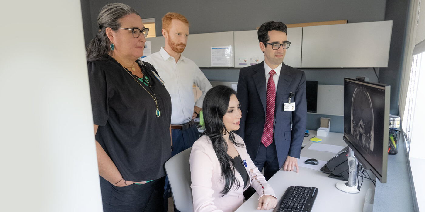 From left, Denise Lally-Goss, ANP, Patrick Codd, MD, Leena Shahla, MD, and Jordan Komisarow, MD look at a brain scan on a computer together.