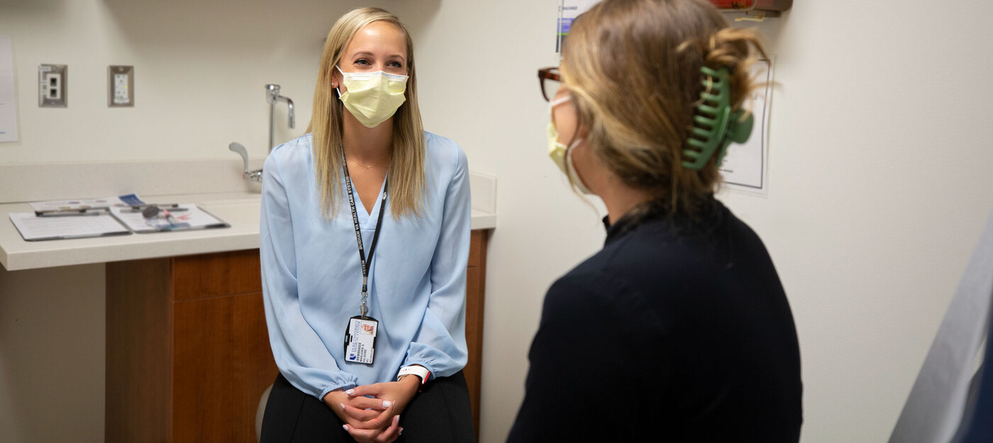 A provider speaks with a patient in clinic