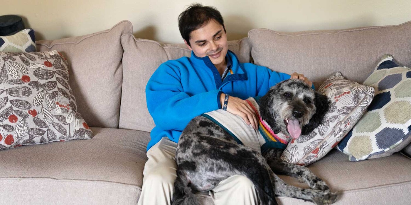 Tyler and his dog cuddle together on a couch