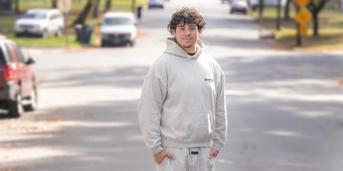 Fernando stands on a street and smiles