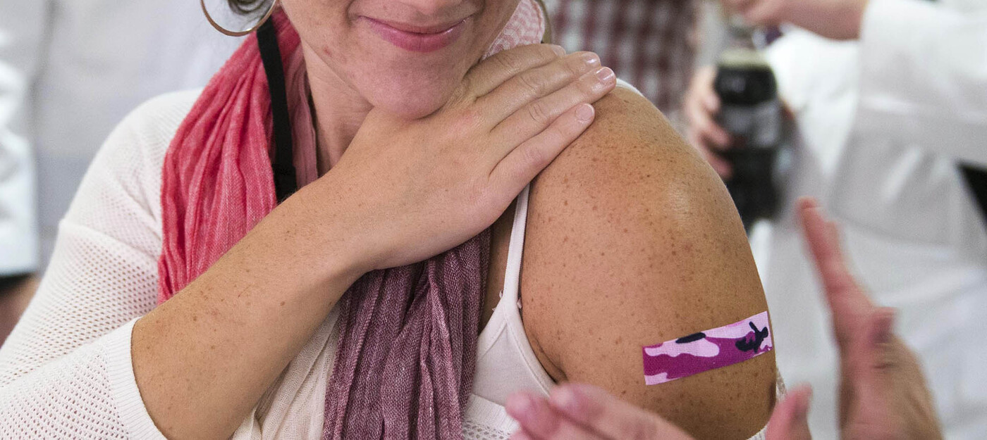 Woman getting bandaid placed after flu vaccination