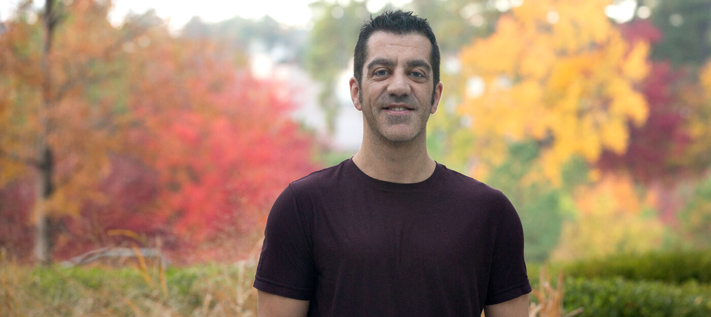 Dan Kummer stands outside in front of fall colors