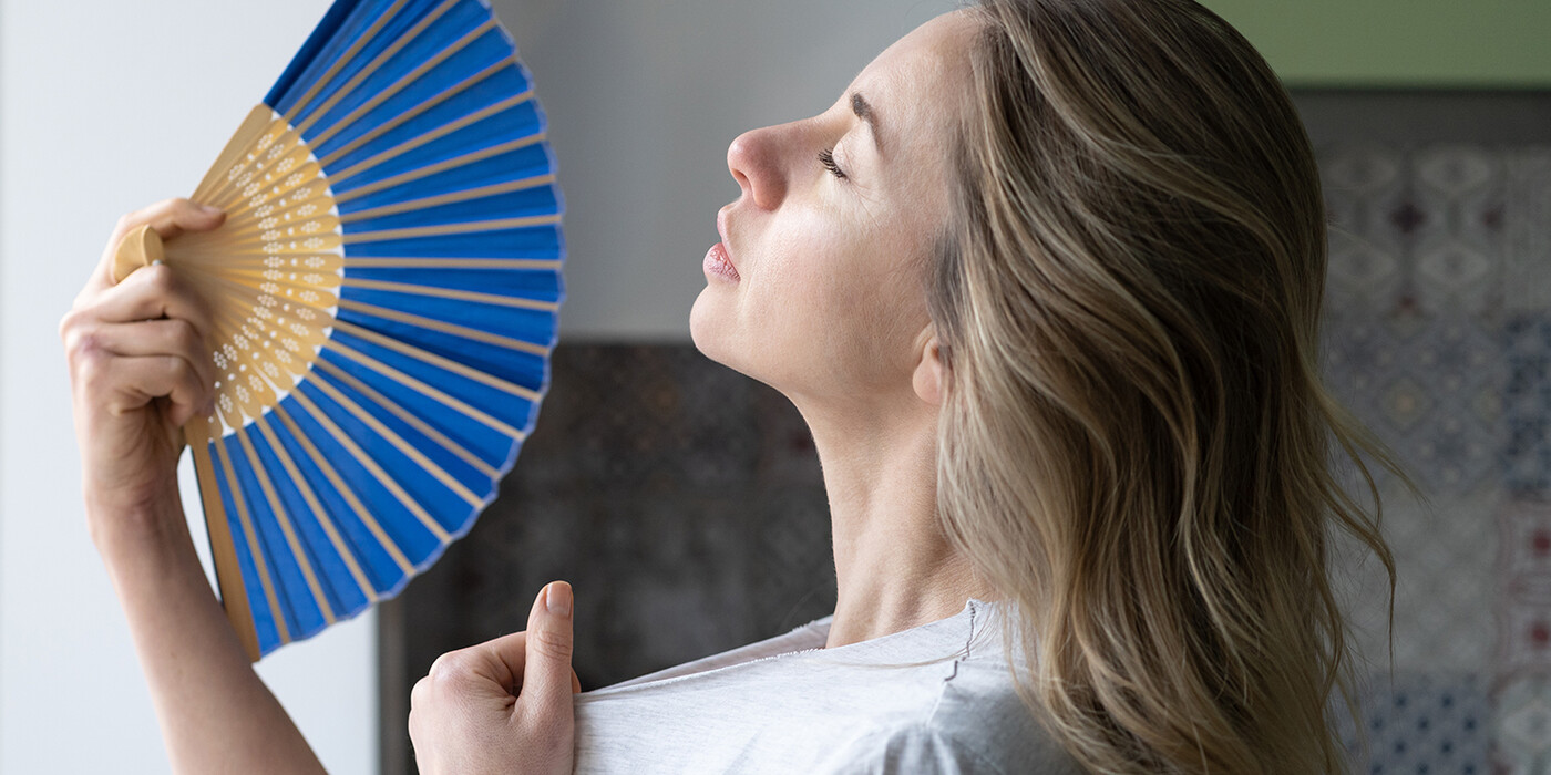 a woman is hot and fanning herself