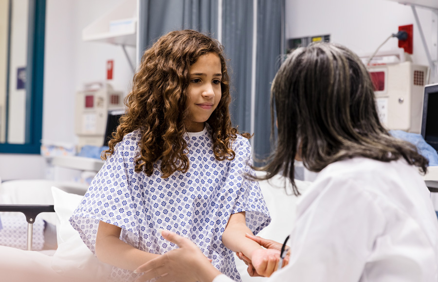 A doctor touches a patient's arm as she examines her in the emergency room