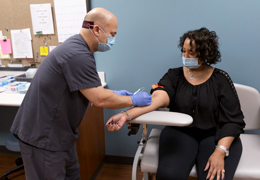 A provider draws blood from a patient